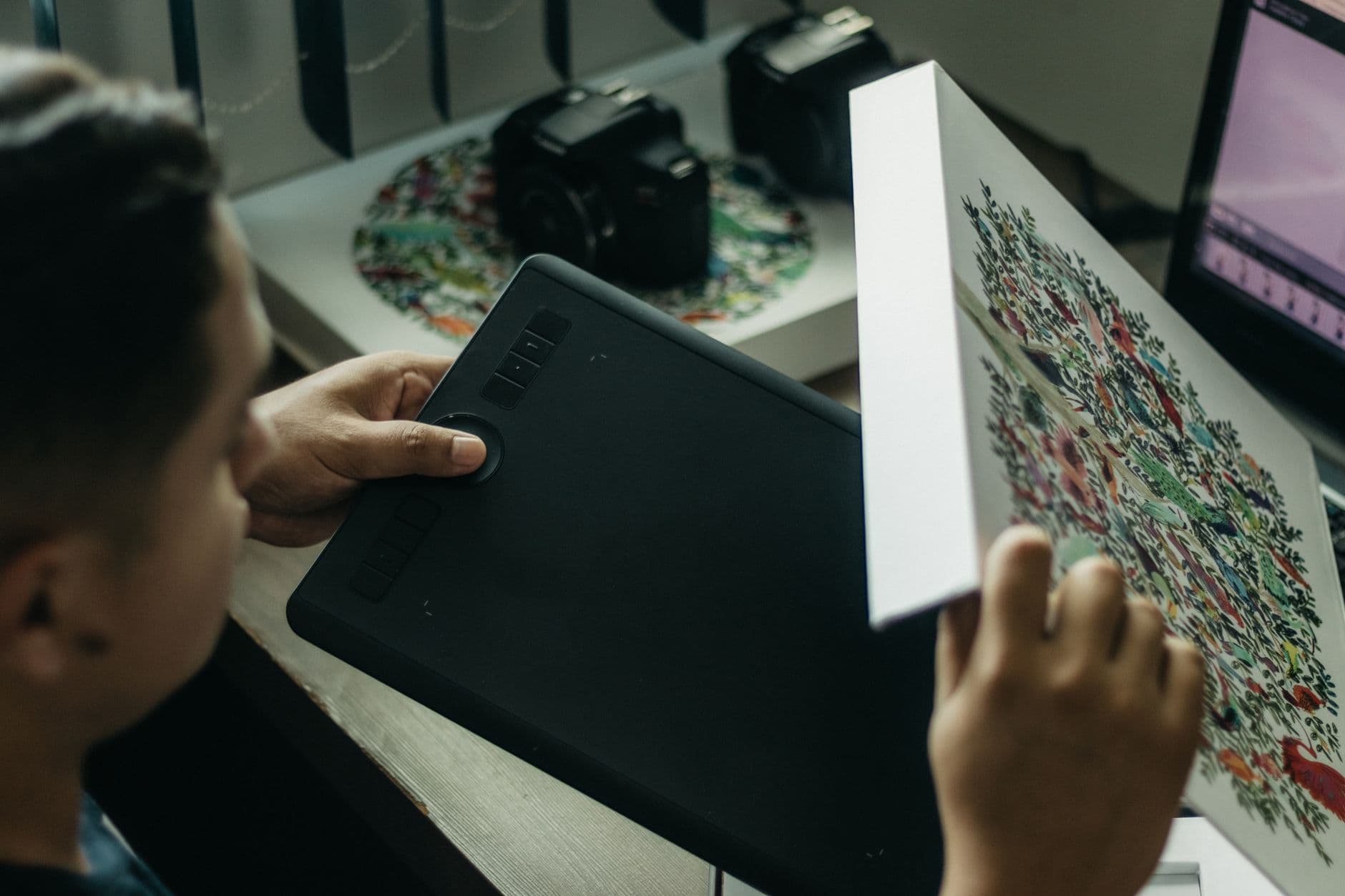 Close-up of a digital artist working with a graphics tablet indoors.
