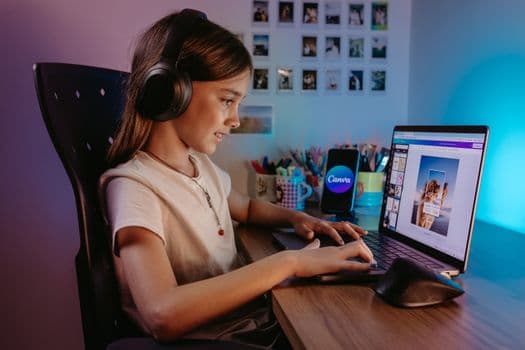 A child using a laptop for creative education with colorful background.
