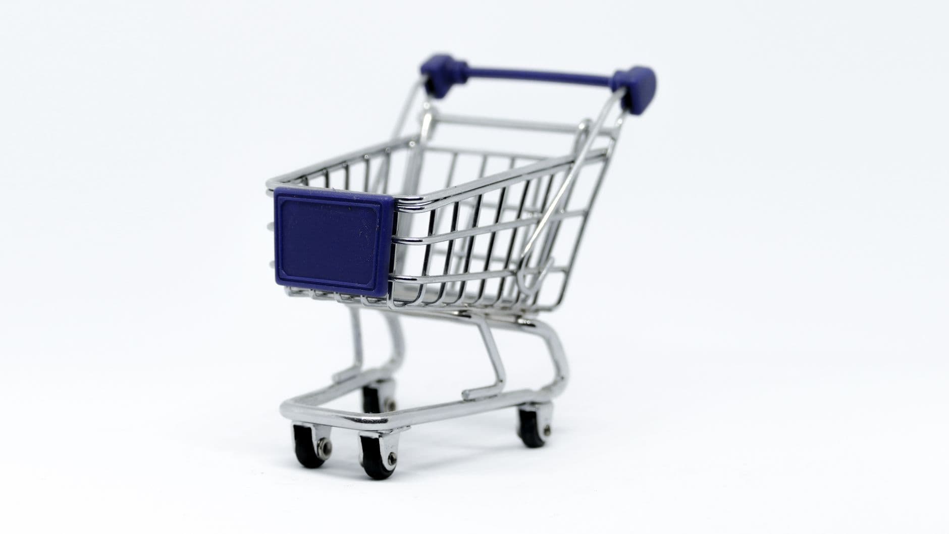 A modern miniature shopping cart on a clean white background, perfect for e-commerce concepts.