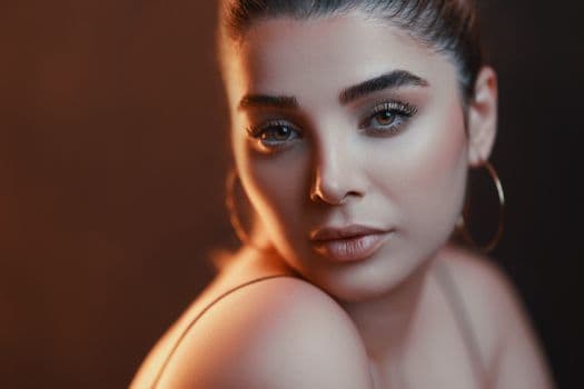 Stunning close-up portrait of a woman with elegant makeup and soft lighting.