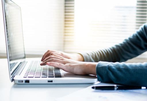 Close-up shot of hands typing on a laptop keyboard, perfect for business or technology themes.