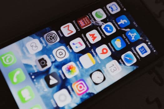 Close-up of a smartphone displaying popular social media and productivity apps on its screen.