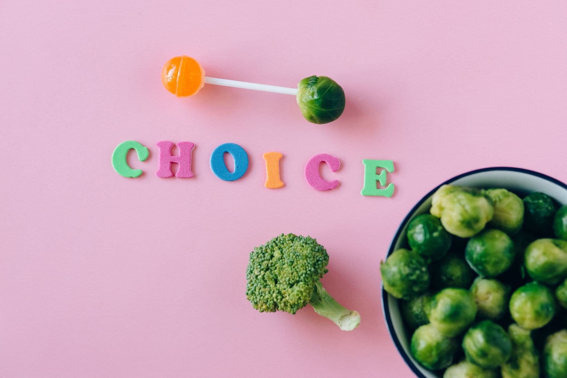 Colorful depiction of healthy and sweet food choices on pink backdrop.