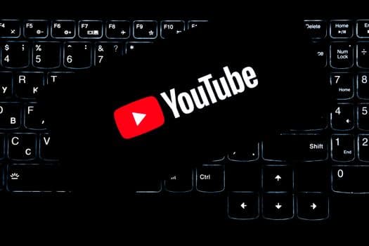 YouTube logo displayed on a backlit keyboard, representing digital media and online content creation.