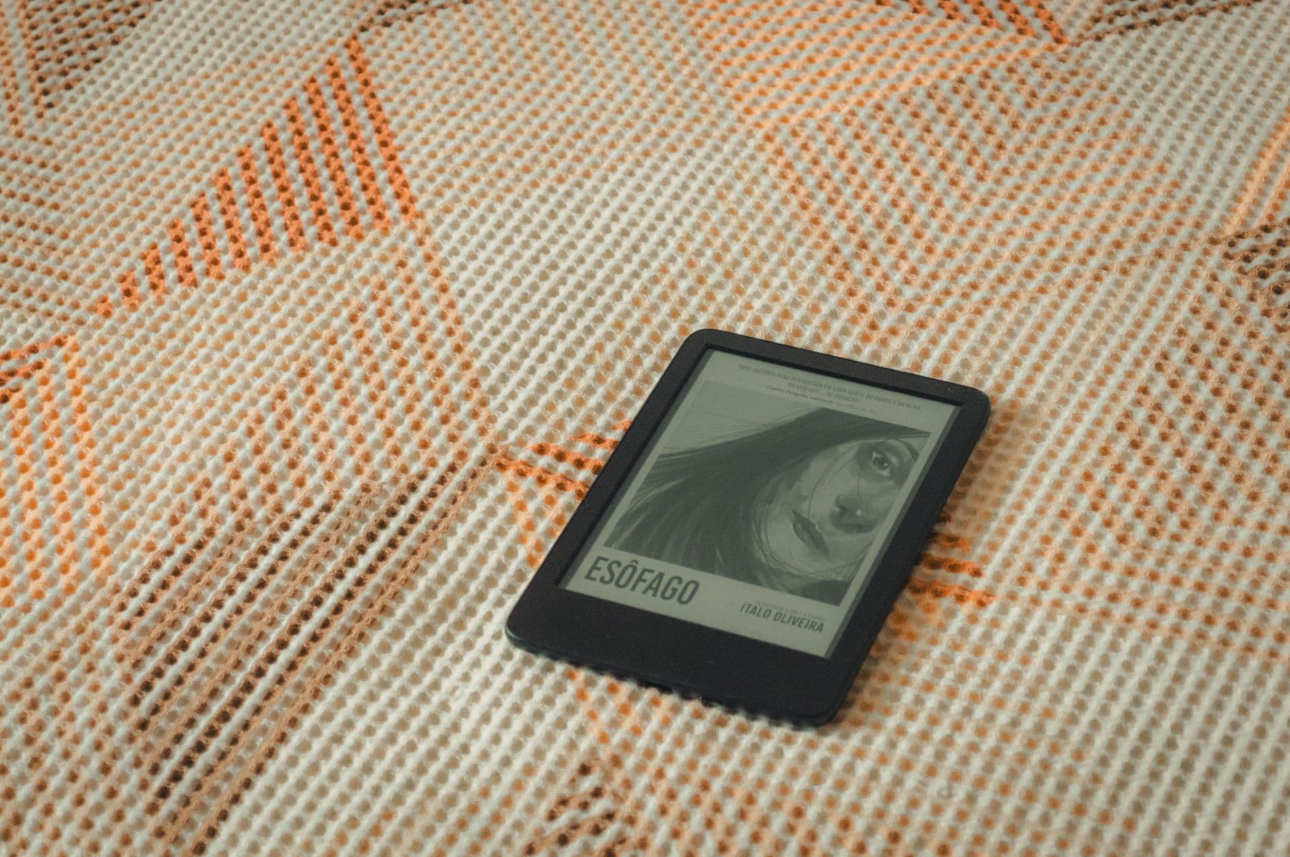 E-reader displaying a book cover on a patterned fabric for a cozy reading moment.