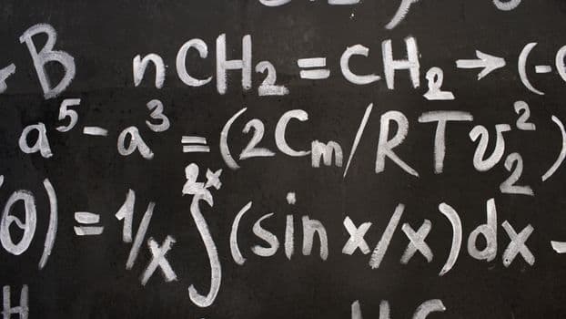 Close-up of complex equations on a chalkboard, showcasing chemistry and math symbols.