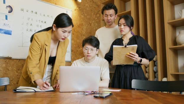 Group of diverse coworkers engaged in a collaborative business meeting at modern office.